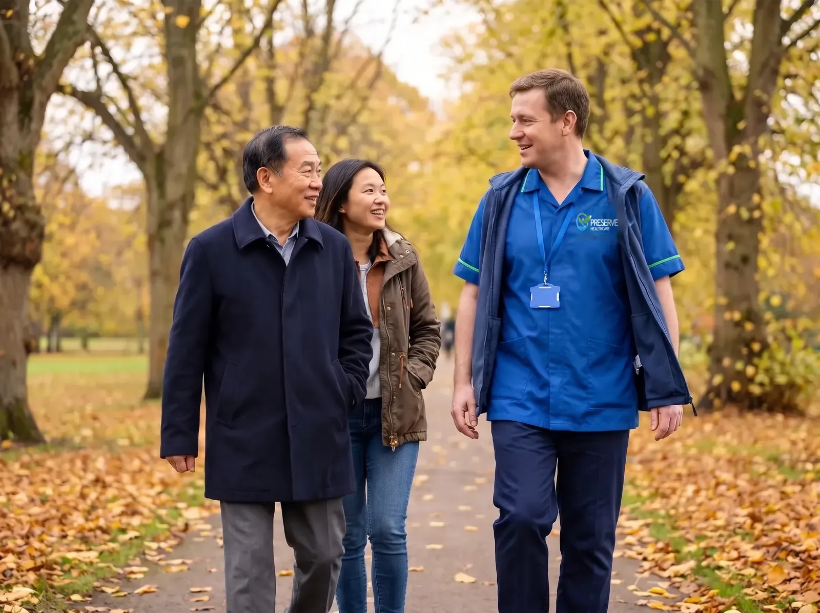 Carer walking in a Coventry park with a man and his daughter as part of wellbeing support involving family